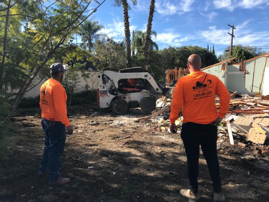 A demolition crew with a bobcat on a residential demolition site for DEMO Leaders in Los Angeles, CA