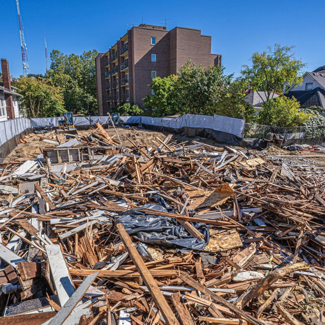 A large pile of wood and construction debris on a cleared lot after demolition by Rainstate Earthworks in Auburn, WA.