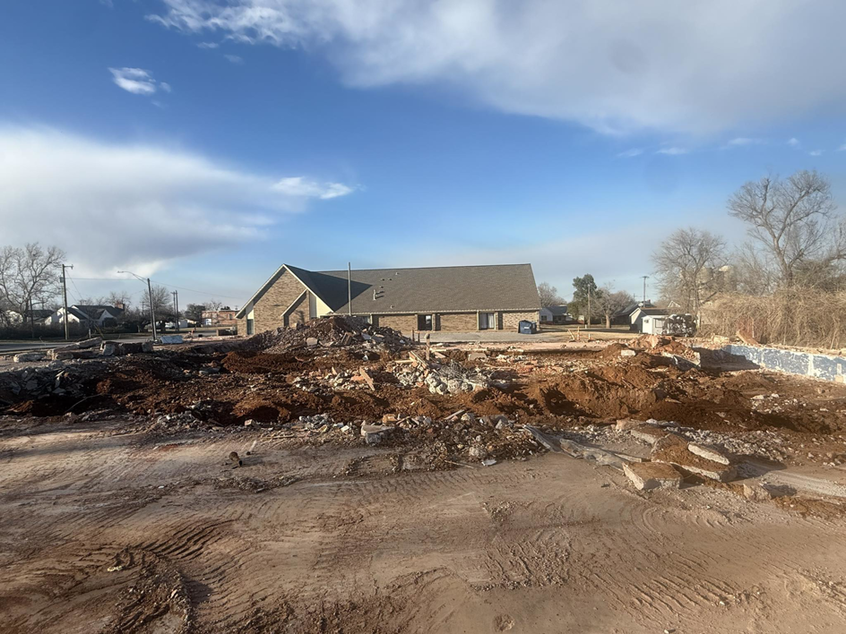 A demolition site with large piles of debris, indicating recent work by Enfield Demolition & Excavation LLC in Enid, OK.