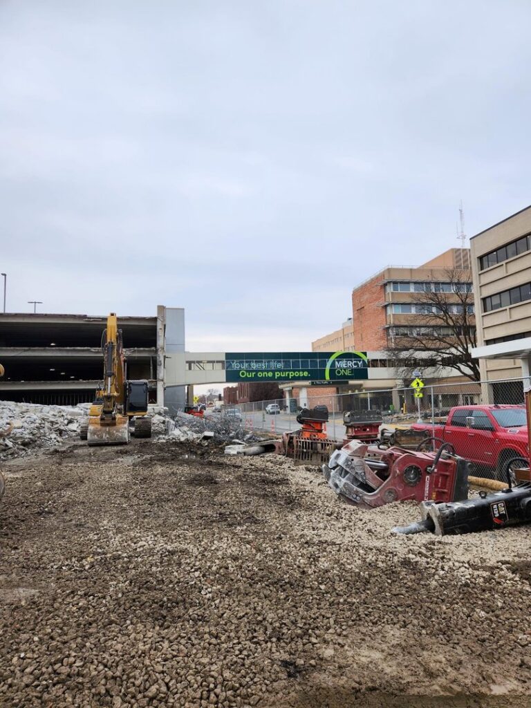 A demolition site featuring heavy machinery and debris, managed by DeCarlo Demolition Company in Des Moines, IA.
