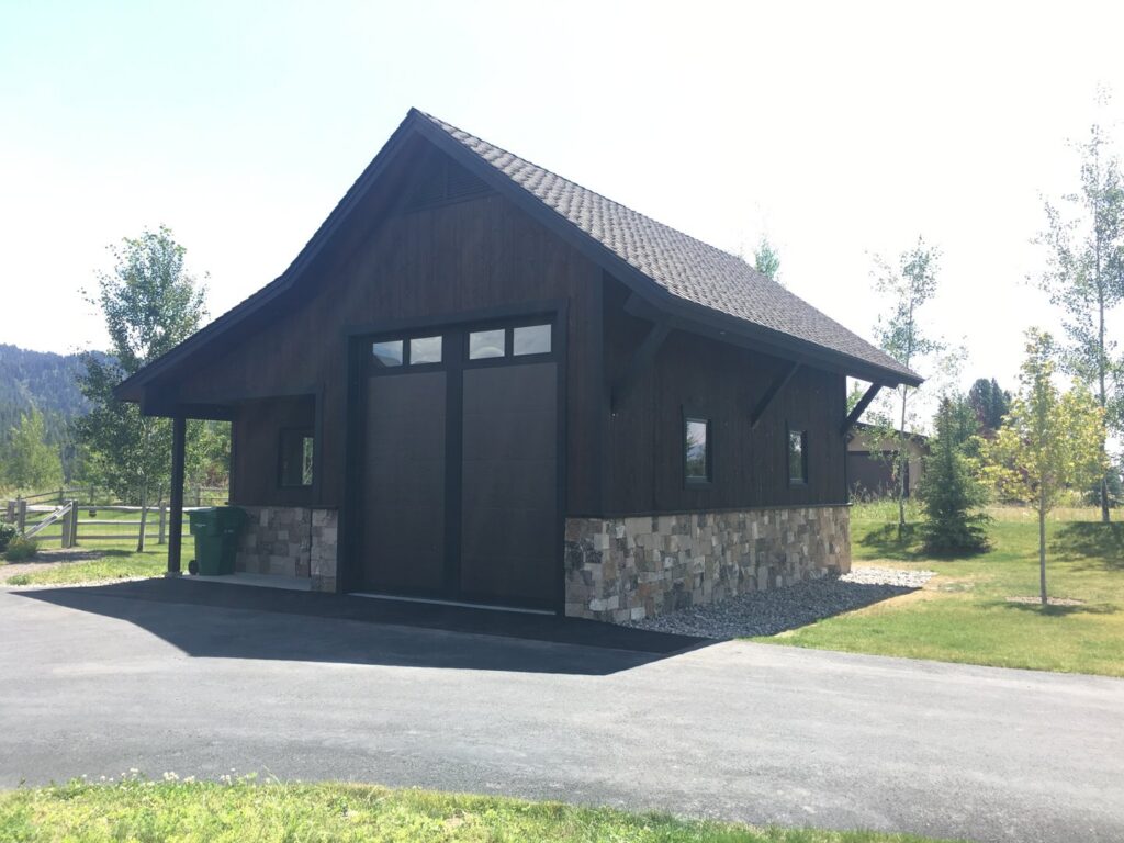Detached garage with two dark modern garage doors installed by Garage Door Store Boise, ID.