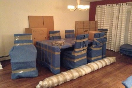Dining room furniture, including table and chairs, wrapped for protection by Moving Pros LLC in Surprise, AZ.
