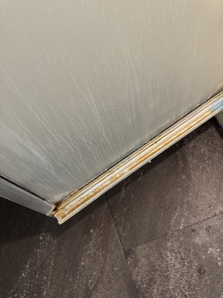 A dirty corner of a kitchen appliance and floor before house cleaning by Grant Cleaning in Missoula, MT.