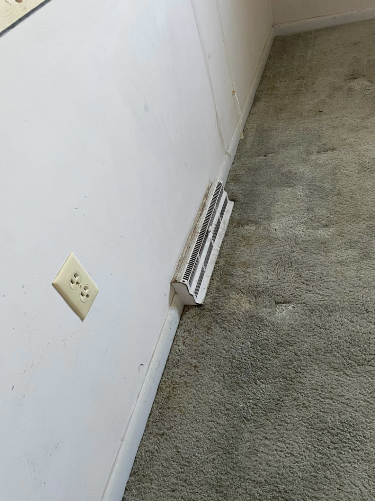 A dirty baseboard heater and carpet in a residential room, needing deep cleaning by Deep Cleaning Service in Frederick, MD.