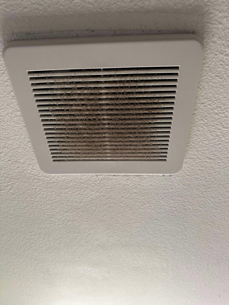 A very dirty bathroom exhaust fan cover before professional cleaning by Nannie Needs LLC in Kent, WA.