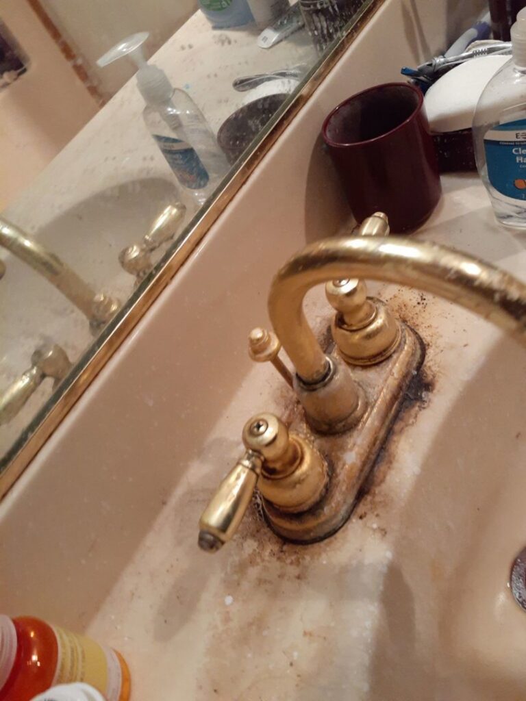 A close-up of a dirty bathroom faucet with hard water stains and grime, ready for cleaning by L & G Cleaning Service in Aurora, CO.