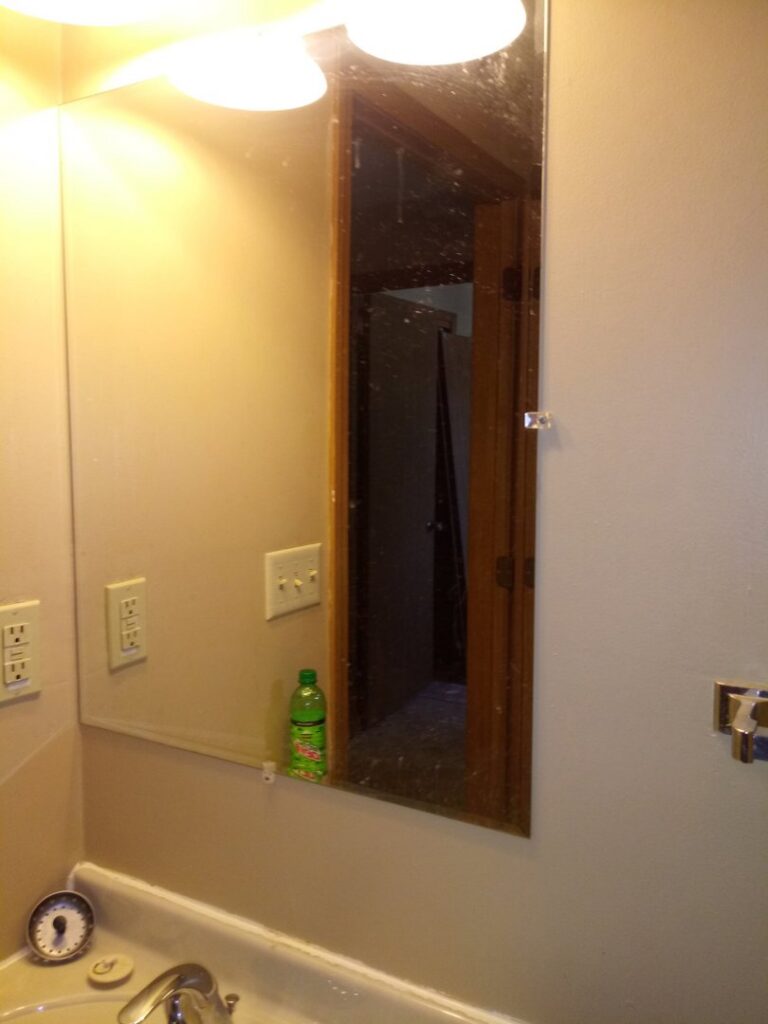 A dirty bathroom mirror with visible streaks and spots, ready for cleaning by L & G Cleaning Service in Aurora, CO.
