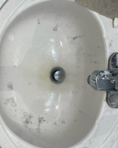 A dirty bathroom sink with grime and water spots, ready for cleaning by Stephie's From Dust To Glitter in Detroit, MI.