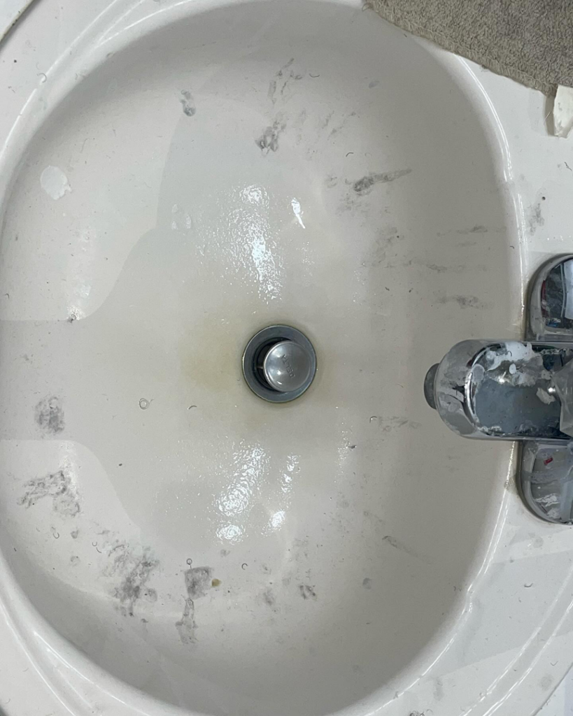 A dirty bathroom sink with grime and water spots, ready for cleaning by Stephie's From Dust To Glitter in Detroit, MI.