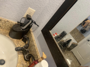 A dirty bathroom sink, faucet, and mirror showing grime, ready for cleaning by Cleaning with Care in Fayetteville, AR.