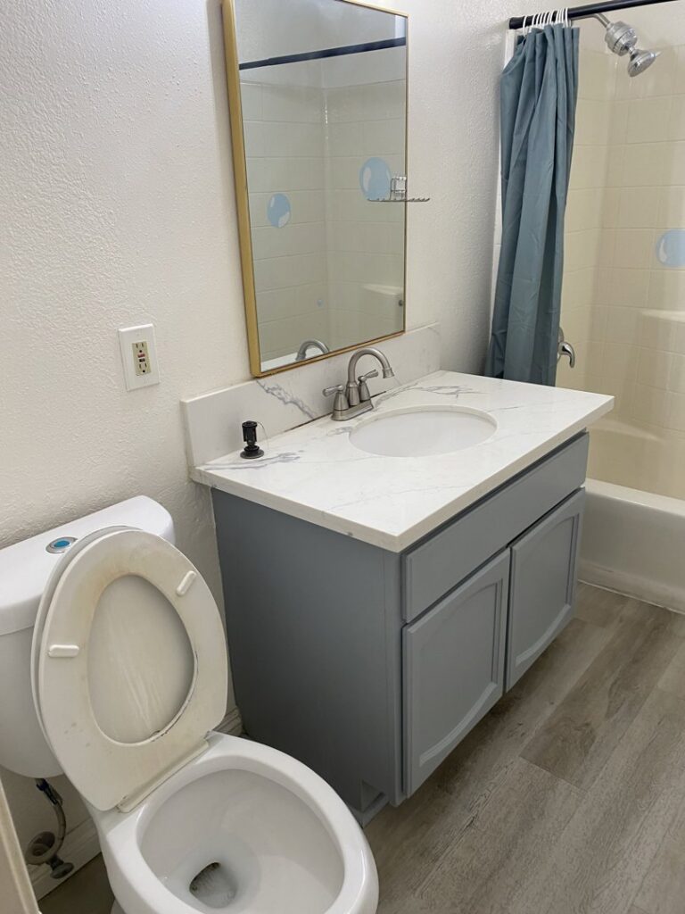 A dirty bathroom toilet and vanity, showing a 'before' state for cleaning services by Maid 2 Clean San Diego, CA