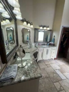 A bathroom vanity with smudged mirrors and a dusty counter, indicating a need for cleaning by Inspire Clean OKC in Oklahoma City, OK.
