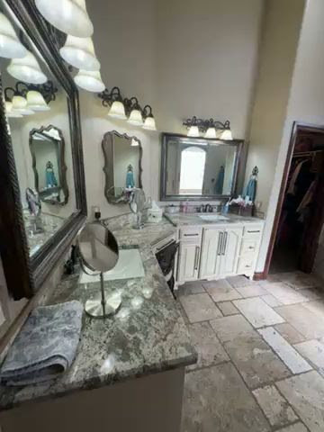 A bathroom vanity with smudged mirrors and a dusty counter, indicating a need for cleaning by Inspire Clean OKC in Oklahoma City, OK.