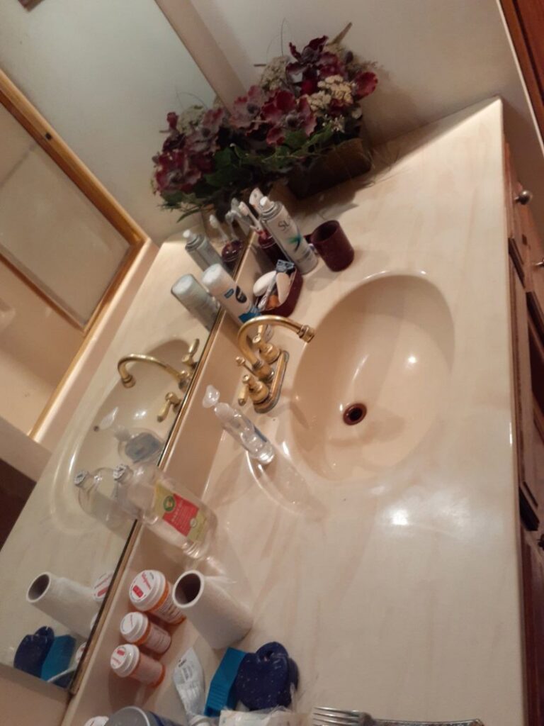 A very dirty and cluttered bathroom vanity with two sinks, showing an area needing cleaning by L & G Cleaning Service in Aurora, CO.