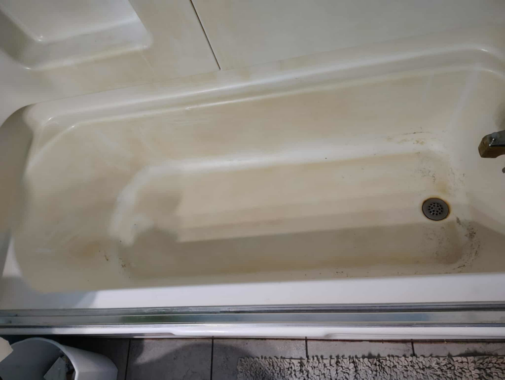 A dirty bathtub showing grime and stains before cleaning by Carissa's Green Cleaning LLC in Toledo, OH.