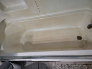 A dirty bathtub showing grime and stains before cleaning by Carissa's Green Cleaning LLC in Toledo, OH.