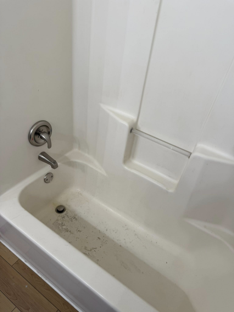 A dirty bathtub showing grime and soap scum, indicating a need for cleaning by Divine Cleaning in Fargo, ND.