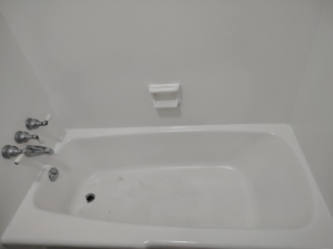 A dirty white bathtub showing grime before professional cleaning by Dulce's cleaning service in Dana Point, CA.
