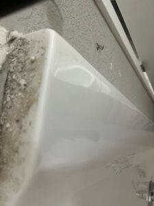 A close-up of a dirty bathtub edge and grout, showing an area in need of professional cleaning from A+ Residential Cleaning Services in Champaign, IL.
