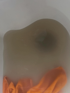 Murky water in a bathtub with an orange cleaning cloth, showing dirt removed during a deep clean by BLACK PEARL Cleaning CO. in Greenwood, MO.