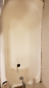 A dirty bathtub with visible mildew and grime before professional cleaning by Windham Cleaning in Akron, OH.