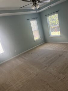 A bedroom with a dirty carpet showing visible stains, indicating a need for professional house cleaning by Royal Madam Cleaning LLC in Charlotte, NC.