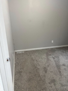 A dirty carpeted room with visible dust and debris before cleaning by Tri-State Clean Queen in Elsmere, KY.