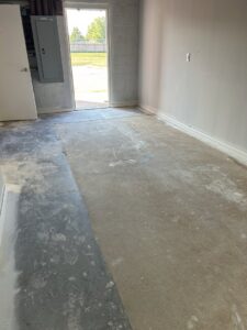 A dirty concrete floor in a garage or basement before cleaning by Perfections Quality Cleaning Service in Dayton, OH.