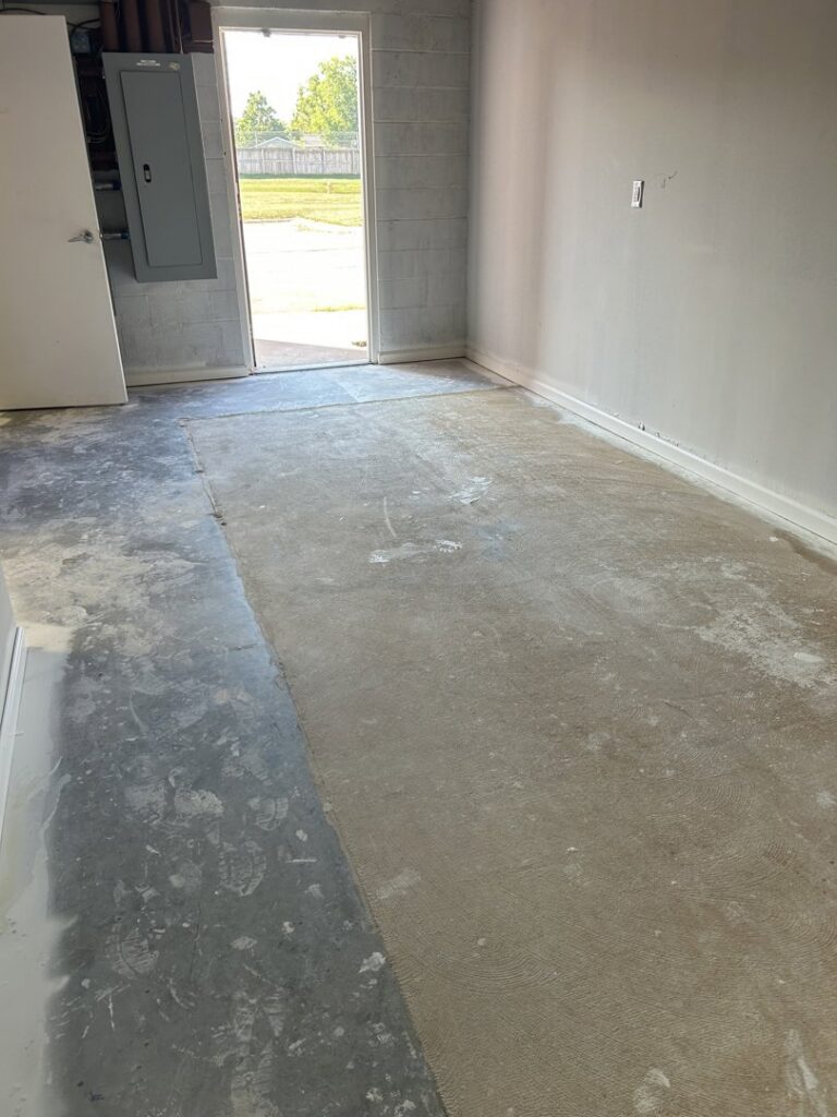 A dirty concrete floor in a garage or basement before cleaning by Perfections Quality Cleaning Service in Dayton, OH.