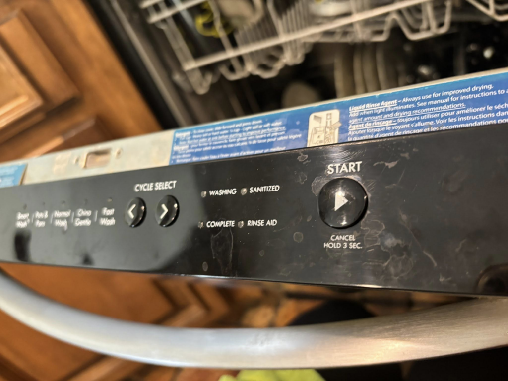 A dirty dishwasher control panel showing smudges, ready for cleaning by Cleaning by Design LLC in Frederick, MD.