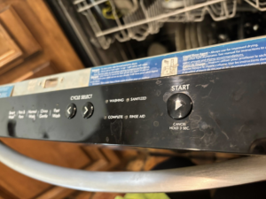A dirty dishwasher control panel showing smudges, ready for cleaning by Cleaning by Design LLC in Frederick, MD.