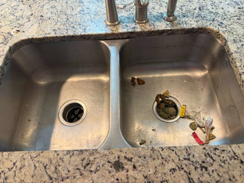 A dirty double kitchen sink with food debris, showing an area needing professional cleaning by New Image Cleaning Service LLC in Richmond, VA.
