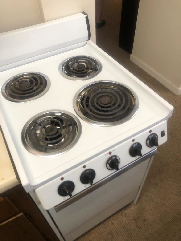 A dirty electric stove with visible grime on the burners, ready for a professional cleaning service from Maids of Hartford in Hartford, CT.