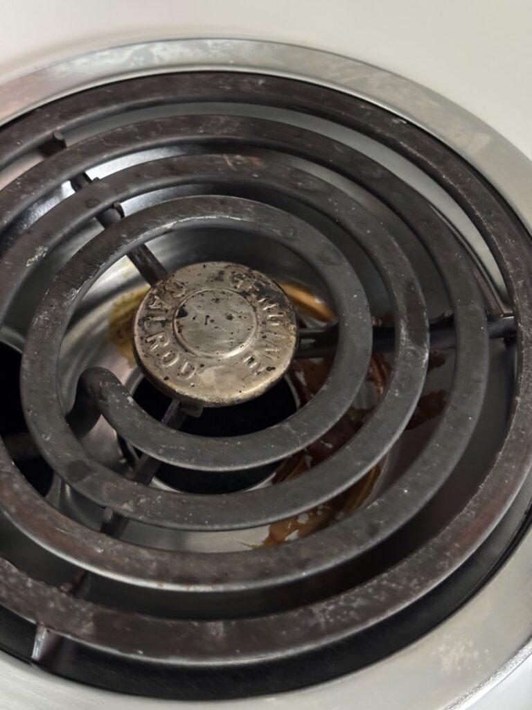 A dirty electric stove burner with visible food grime, ready for cleaning by Lindi's Clean Living, LLC in Tucson, AZ.