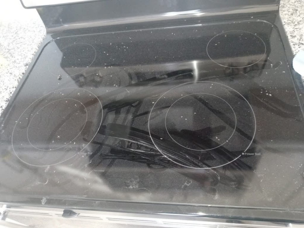 A dirty electric stove top covered in crumbs before professional cleaning by Little Springs Cleaning in Chattanooga, TN.