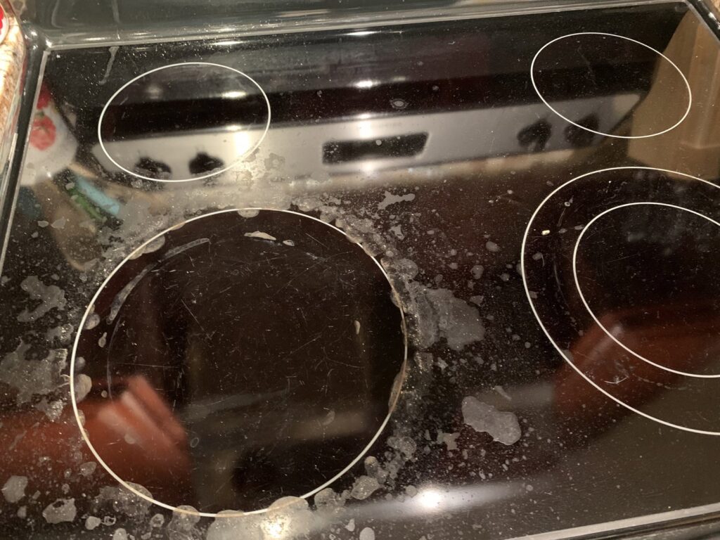 A close-up of a dirty electric stovetop with visible grime and residue, before cleaning by Jolley Services, INC in Bossier City, LA.