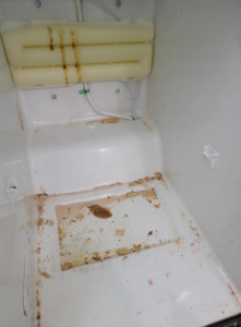 A dirty freezer interior with food debris and spills before professional cleaning by Windham Cleaning in Akron, OH.