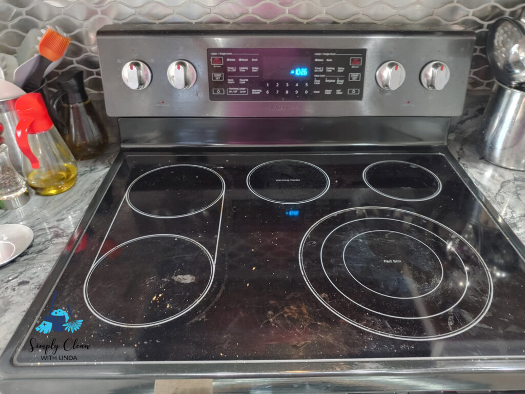 A dirty glass stovetop with visible spills and grime, ready for a professional clean by AG Simply Clean in Concord, NC.