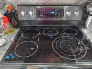 A dirty glass stovetop with visible spills and grime, ready for a professional clean by AG Simply Clean in Concord, NC.