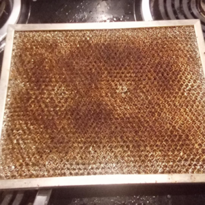 A very dirty and greasy range hood filter, showing a common cleaning challenge for Anna's cleaning house in Sun Valley, CA.