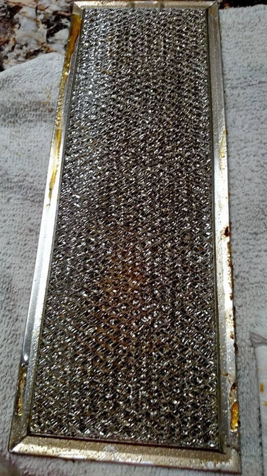 A dirty and greasy range hood filter, ready for a thorough cleaning by Maid It Dirty Cleaning Company in Phoenix, AZ.