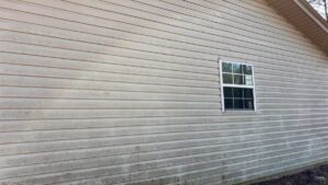 Dirty house siding covered in mold and grime before power washing by Plains Power Washing in Auburn, AL.