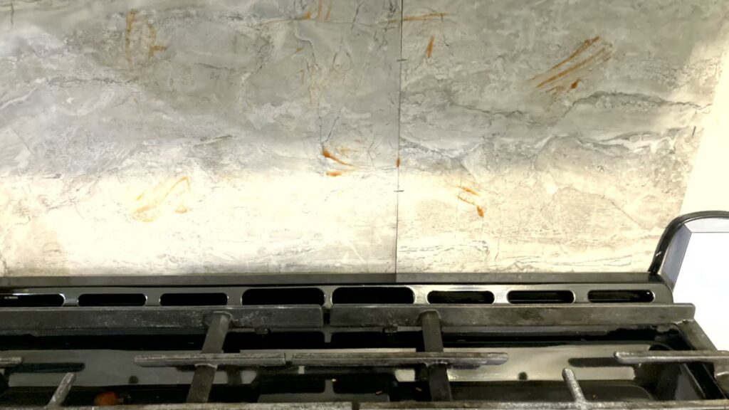 A dirty kitchen backsplash and area above the stove needing cleaning by G & S Cleaning Services in Somerville, NJ.