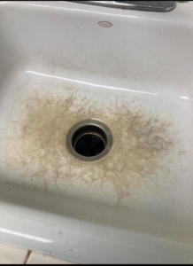 A dirty kitchen sink with visible grime and stains around the drain, ready for house cleaning by Cleanaround22 in Daly City, CA.