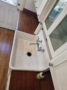 A dirty kitchen sink with visible grime, showing a 'before' state for cleaning by Maid 2 Clean San Diego, CA