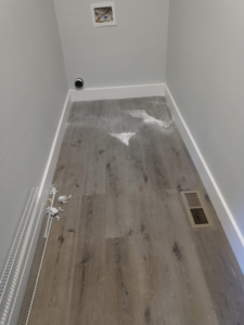 A dirty laundry room floor with construction debris before professional cleaning by Little Springs Cleaning in Chattanooga, TN.