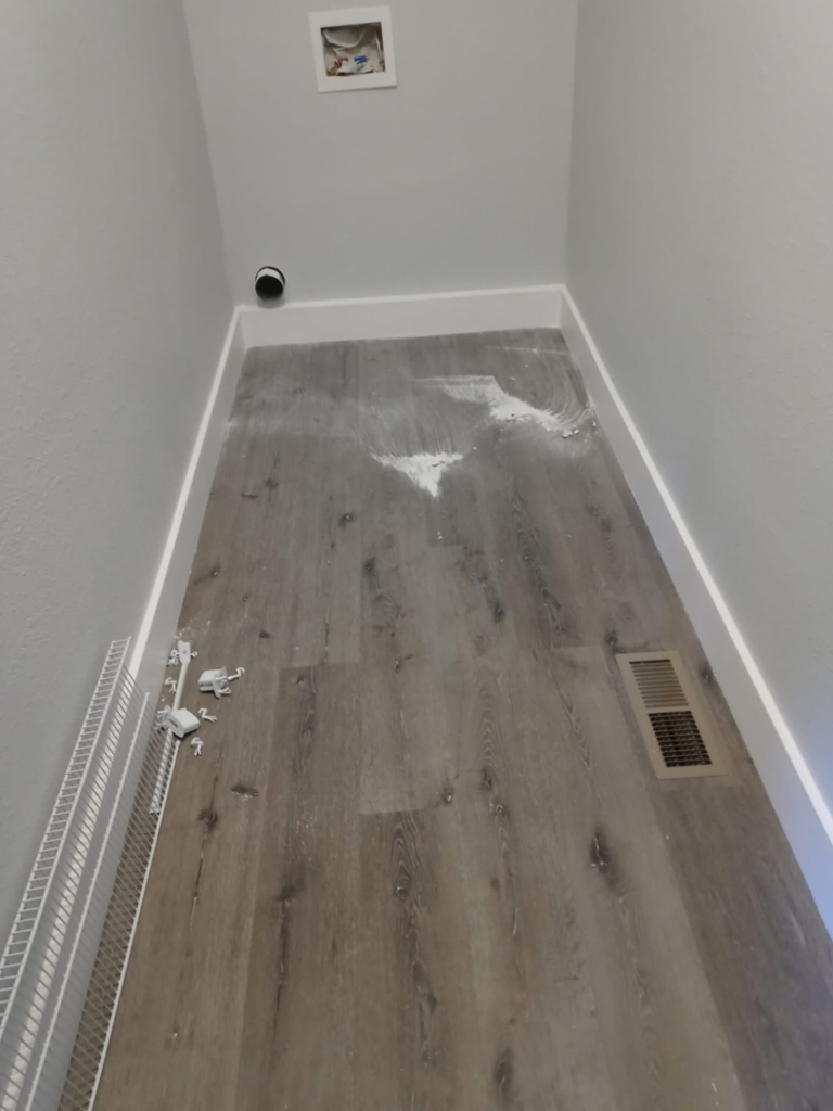 A dirty laundry room floor with construction debris before professional cleaning by Little Springs Cleaning in Chattanooga, TN.