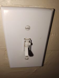 A dirty white light switch with visible smudges and dirt, before professional cleaning by Maid to Serve HIM in Cincinnati, OH.