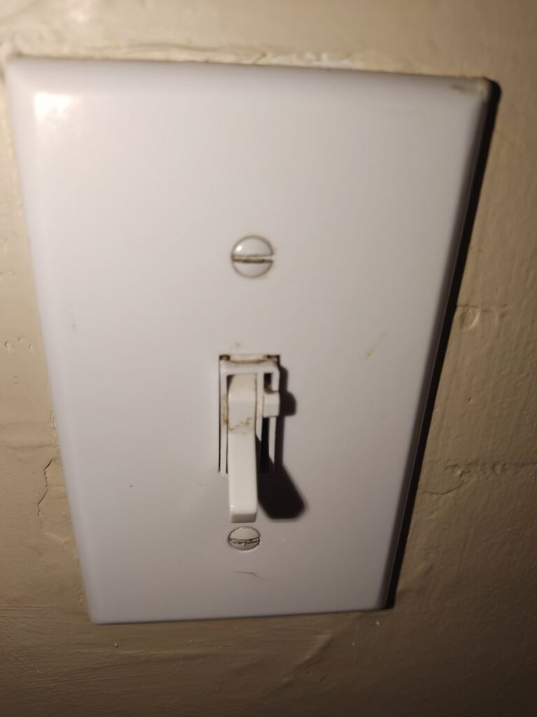 A dirty white light switch with visible smudges and dirt, before professional cleaning by Maid to Serve HIM in Cincinnati, OH.