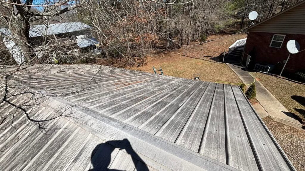 A dirty metal roof covered in grime and streaks before professional cleaning by Plains Power Washing in Auburn, AL.